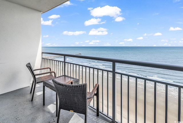 balcony with a water view and a beach view