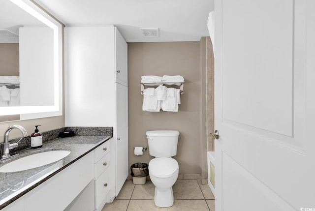 full bathroom featuring toilet, vanity, visible vents, and tile patterned floors