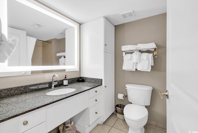 bathroom with toilet, vanity, tile patterned flooring, and visible vents