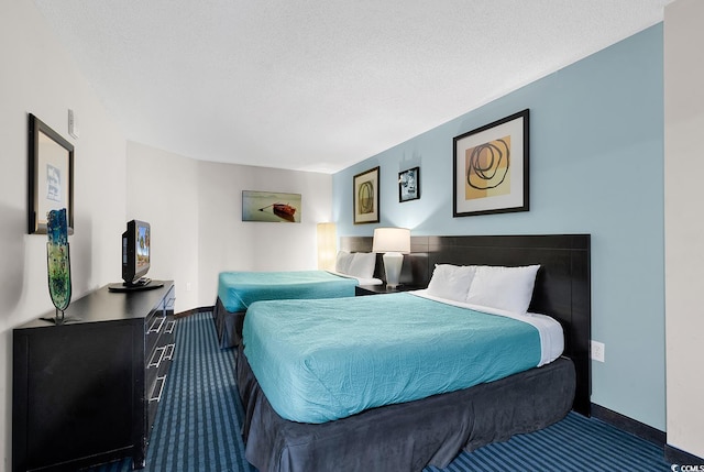 carpeted bedroom with a textured ceiling and baseboards