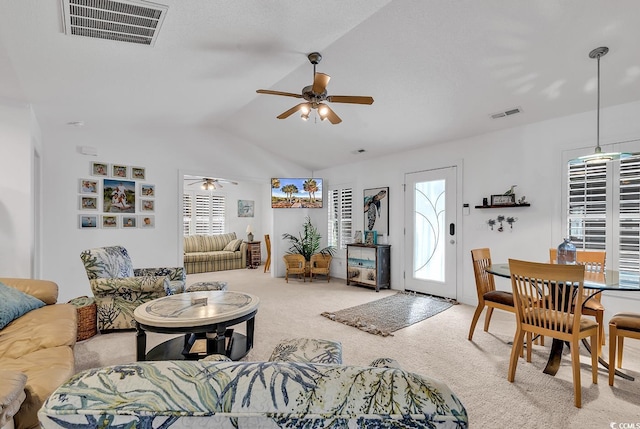 carpeted living area featuring a ceiling fan, lofted ceiling, and visible vents