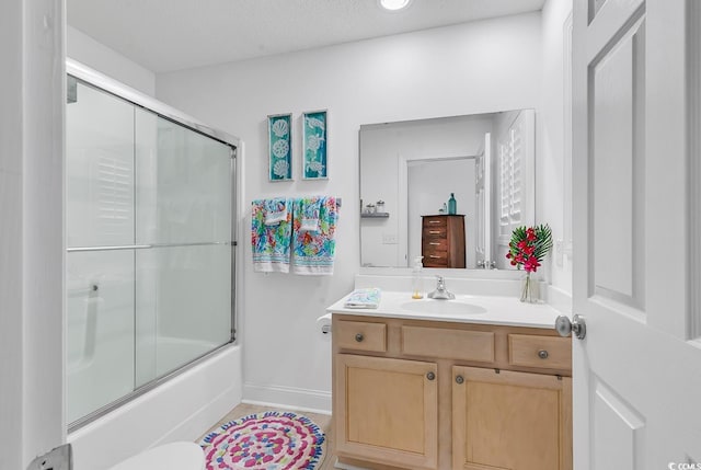 full bath with shower / bath combination with glass door, baseboards, and vanity