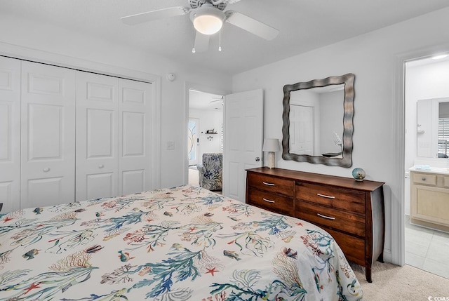 bedroom featuring light carpet, ceiling fan, a closet, and connected bathroom