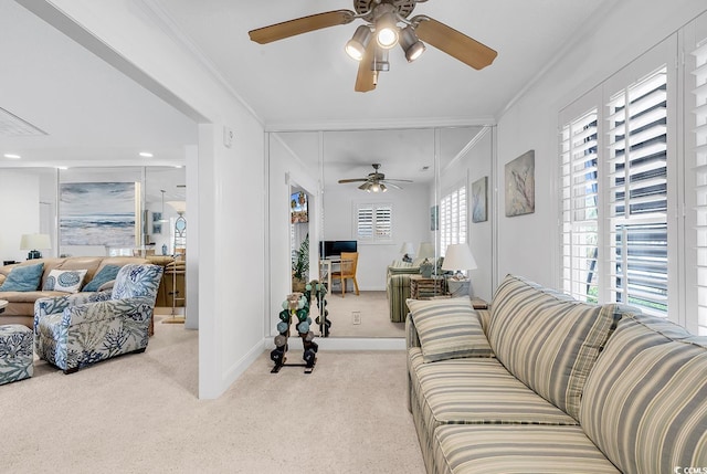 carpeted living room with ornamental molding, baseboards, and a ceiling fan