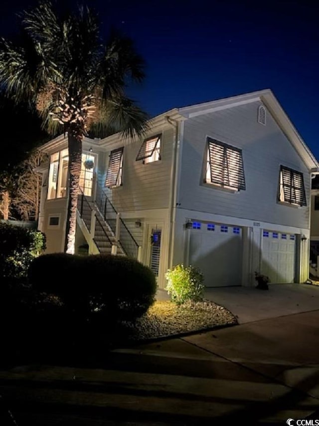 view of front facade featuring an attached garage, stairs, and concrete driveway