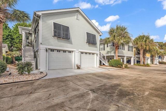 view of front of house featuring stairs, driveway, and an attached garage