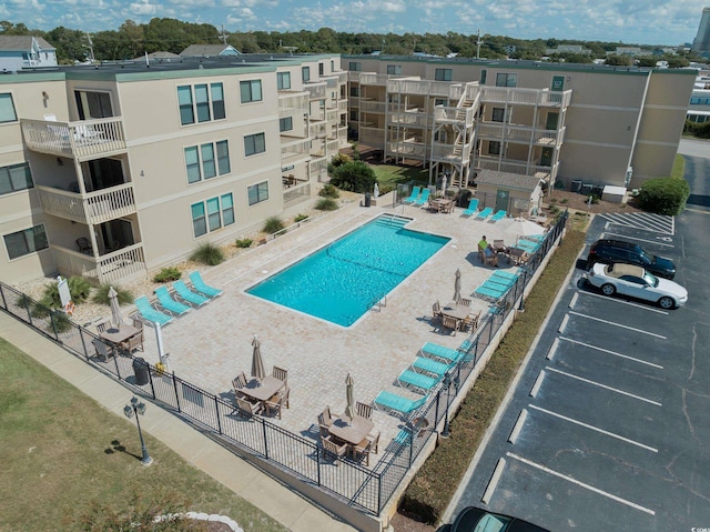 pool with a patio area and fence