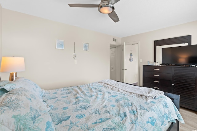 bedroom with a ceiling fan, visible vents, and light wood finished floors