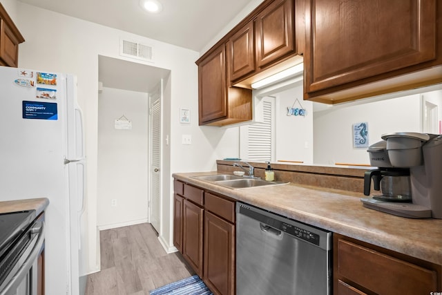 kitchen featuring visible vents, a sink, light countertops, appliances with stainless steel finishes, and light wood-type flooring