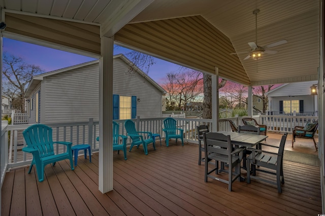 deck at dusk featuring a ceiling fan and outdoor dining area