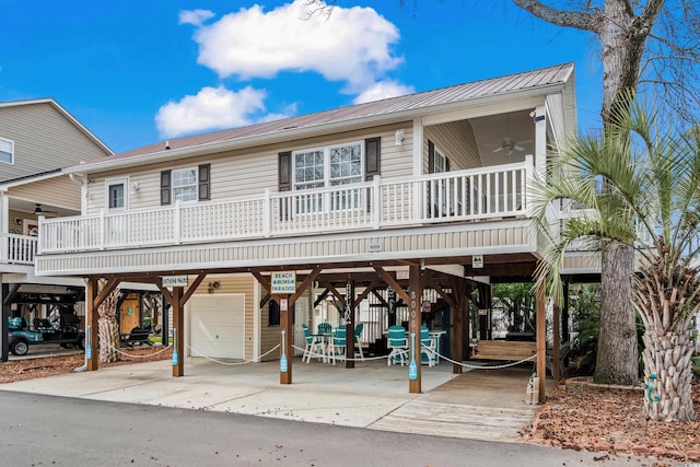 beach home with ceiling fan, metal roof, a carport, and stairs