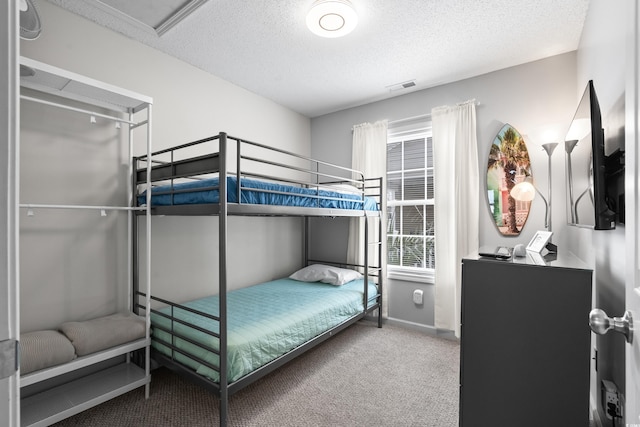 bedroom featuring carpet, visible vents, a textured ceiling, and baseboards