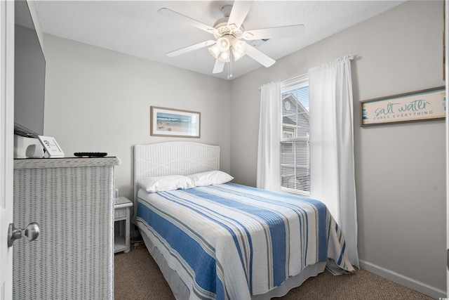 carpeted bedroom with ceiling fan and baseboards