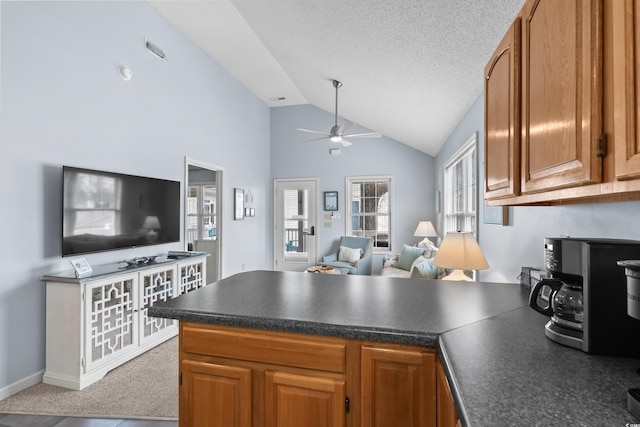 kitchen with dark countertops, open floor plan, and a peninsula