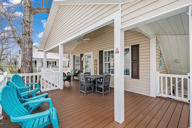 wooden terrace with a ceiling fan and outdoor dining space