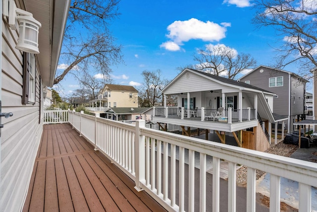 wooden deck featuring a residential view and a ceiling fan