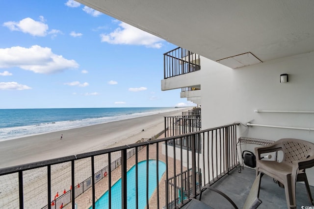 balcony featuring a water view and a view of the beach