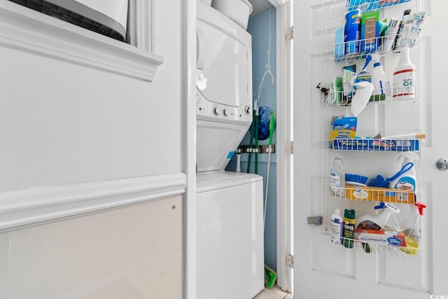 washroom featuring stacked washer / dryer and laundry area