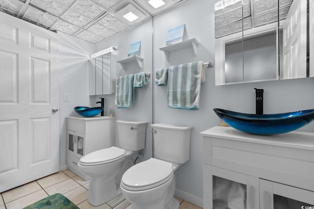 bathroom featuring toilet, baseboards, vanity, and tile patterned floors