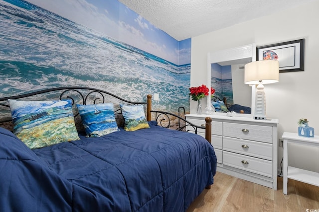 bedroom with light wood finished floors and a textured ceiling