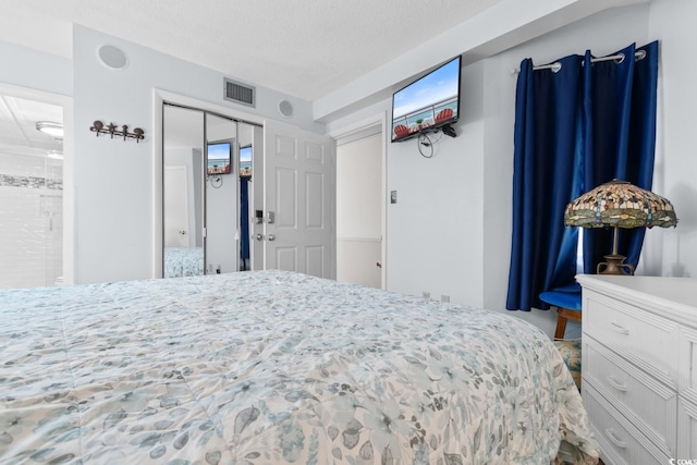 bedroom with a closet, visible vents, and a textured ceiling