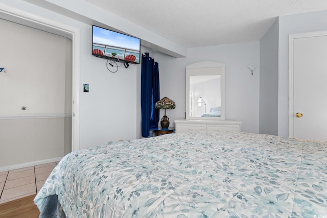 tiled bedroom featuring a textured ceiling