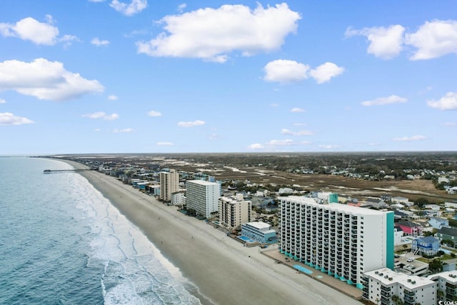 drone / aerial view with a water view, a view of the beach, and a city view