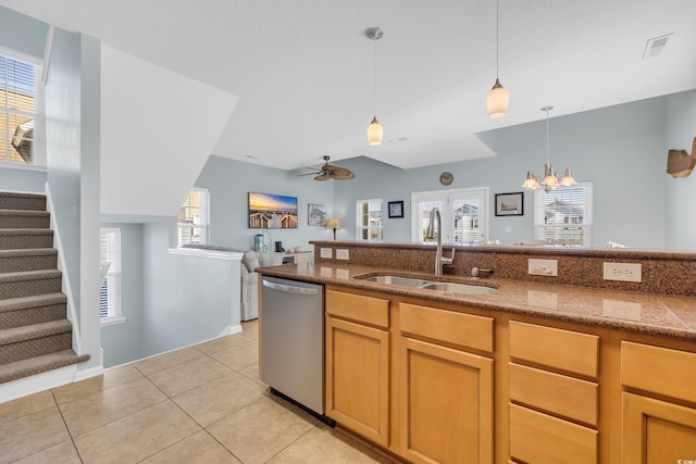 kitchen with light tile patterned floors, ceiling fan with notable chandelier, a sink, hanging light fixtures, and dishwasher