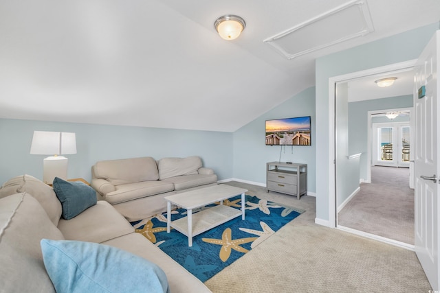 living room featuring attic access, lofted ceiling, carpet flooring, and baseboards