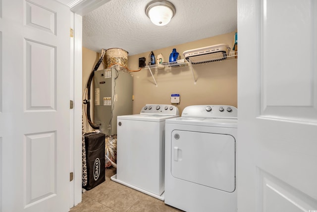 laundry area featuring laundry area, washing machine and dryer, a textured ceiling, and light tile patterned flooring