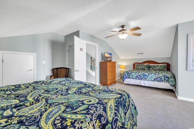 carpeted bedroom with vaulted ceiling, a textured ceiling, baseboards, and ceiling fan