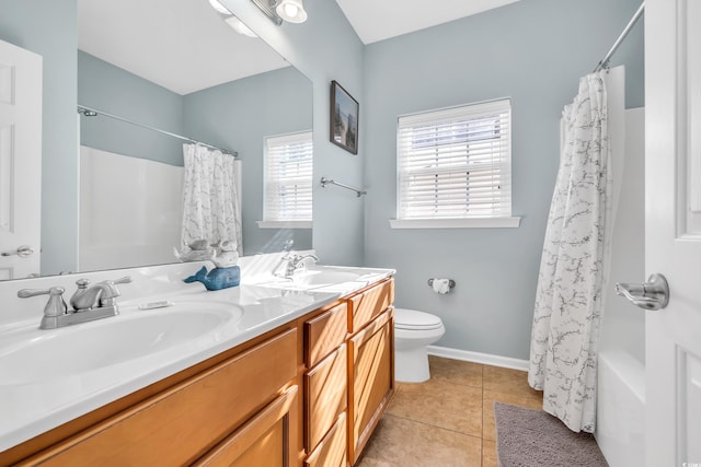 bathroom featuring tile patterned flooring, a sink, toilet, and double vanity