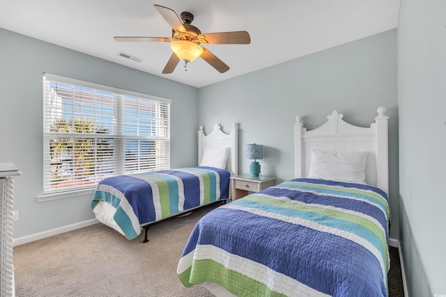 bedroom with a ceiling fan, carpet flooring, visible vents, and baseboards