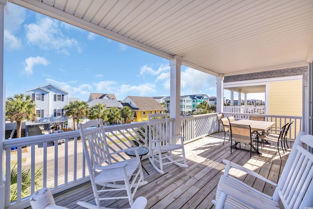 wooden deck featuring outdoor dining area and a residential view