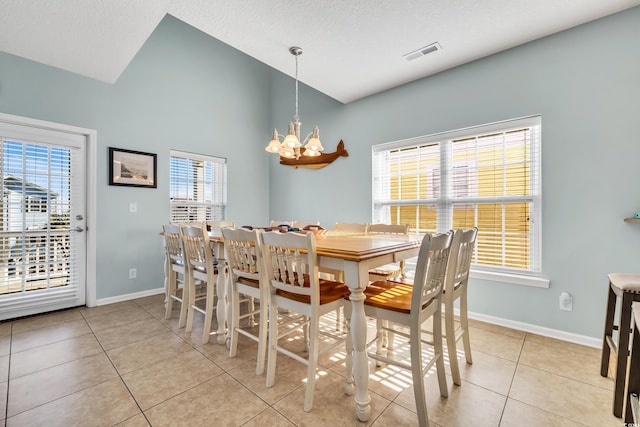 dining space featuring baseboards, visible vents, lofted ceiling, an inviting chandelier, and light tile patterned flooring