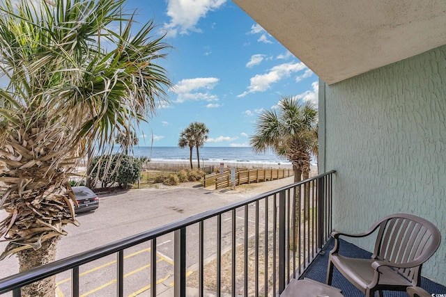 balcony with a water view and a beach view