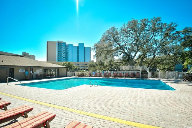 community pool featuring a patio and fence