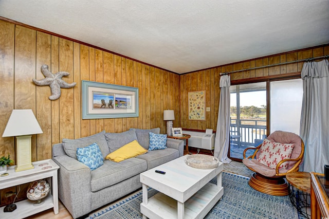 living area featuring a textured ceiling and wood walls