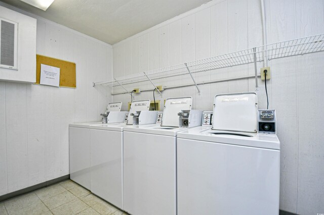 community laundry room with independent washer and dryer and light tile patterned flooring