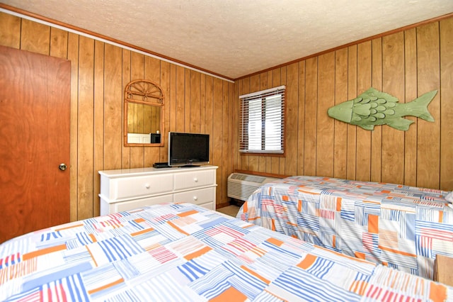 bedroom featuring wood walls, crown molding, a textured ceiling, and an AC wall unit