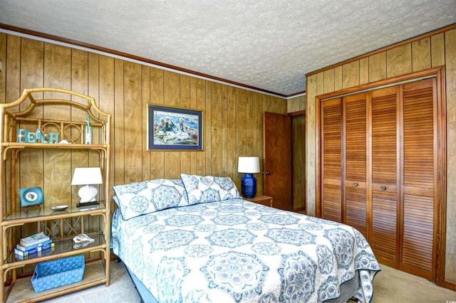 bedroom with ornamental molding, a closet, carpet flooring, and a textured ceiling