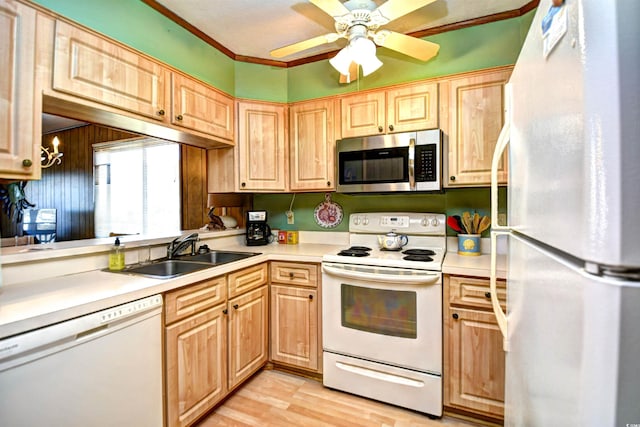 kitchen with white appliances, light countertops, a sink, and light brown cabinetry