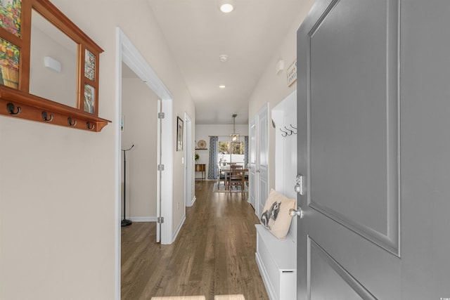 corridor with baseboards, wood finished floors, and recessed lighting