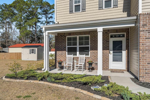 entrance to property featuring covered porch and brick siding