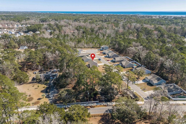 drone / aerial view featuring a water view and a forest view