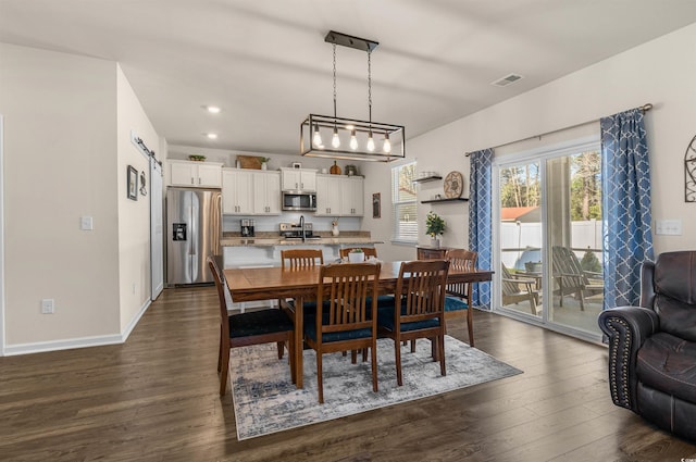 dining space featuring recessed lighting, visible vents, a barn door, dark wood-type flooring, and baseboards