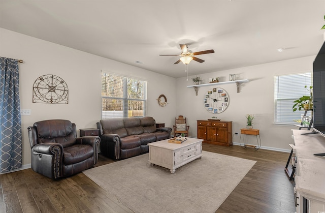 living area with dark wood-style floors, baseboards, and a ceiling fan