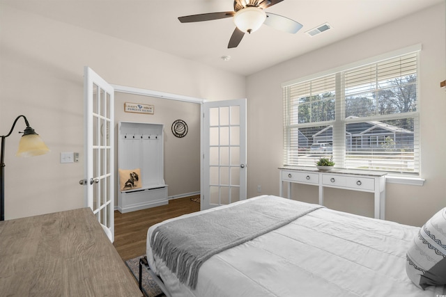 bedroom featuring a ceiling fan, visible vents, wood finished floors, and french doors