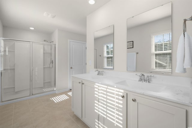 full bath with double vanity, a stall shower, tile patterned flooring, and a sink