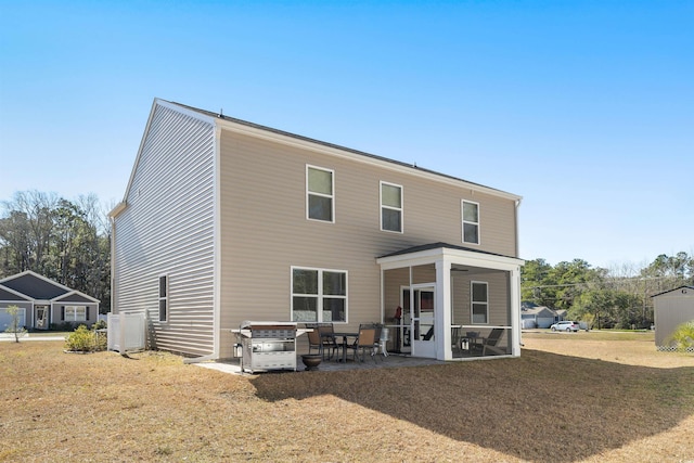 back of property featuring a sunroom, a lawn, and a patio